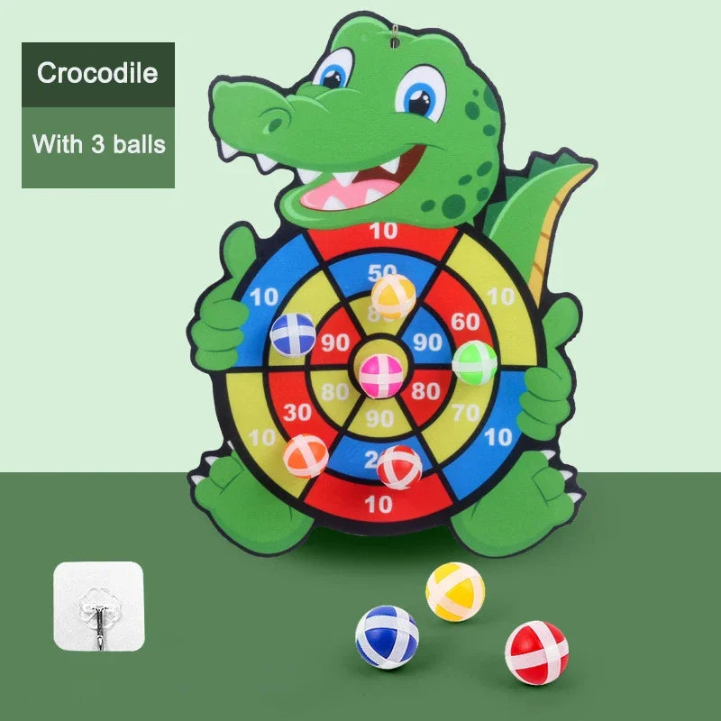 Crocodile-shaped dartboard with three balls on a green background