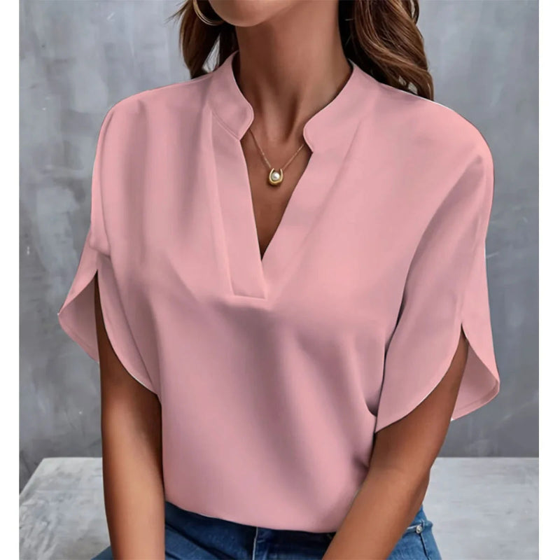 Pink blouse worn by a person against a gray background