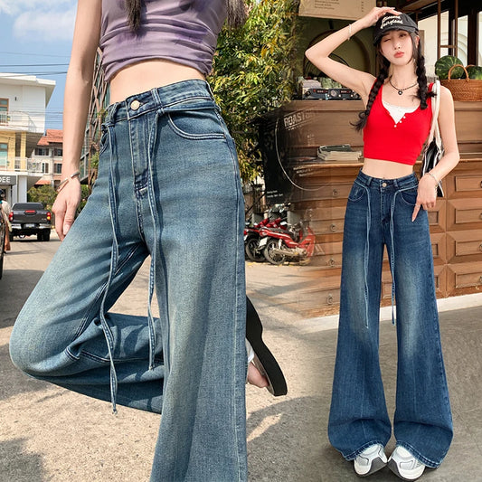 Two people wearing blue flared jeans in an urban setting.