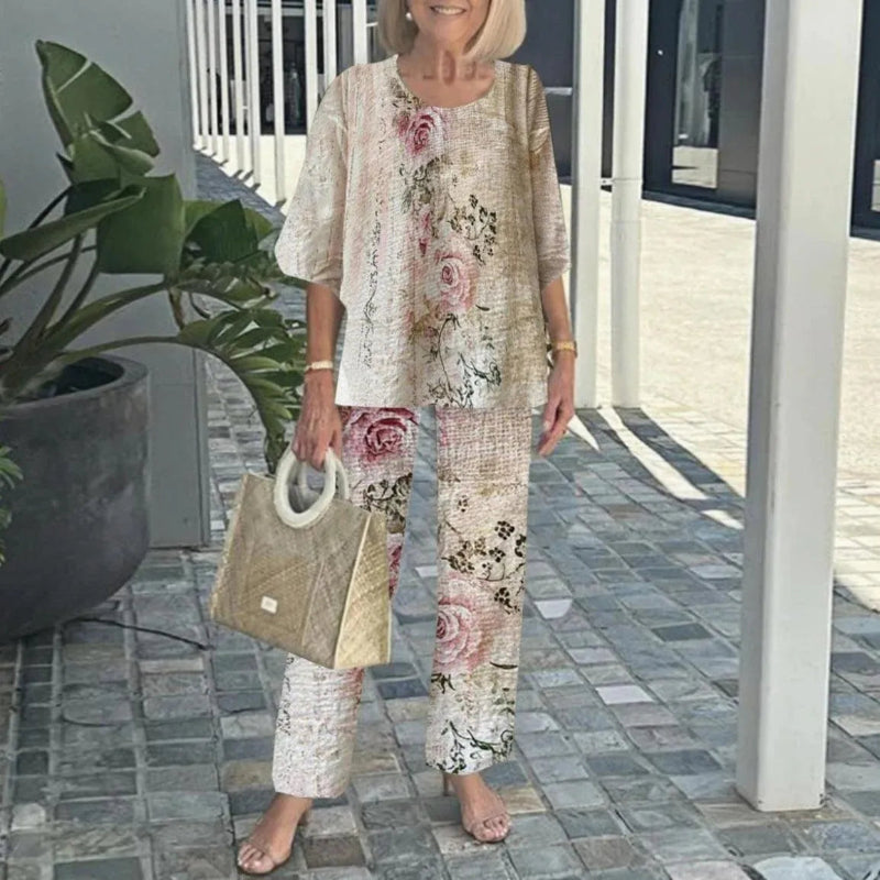 Woman in floral outfit holding a beige handbag outdoors