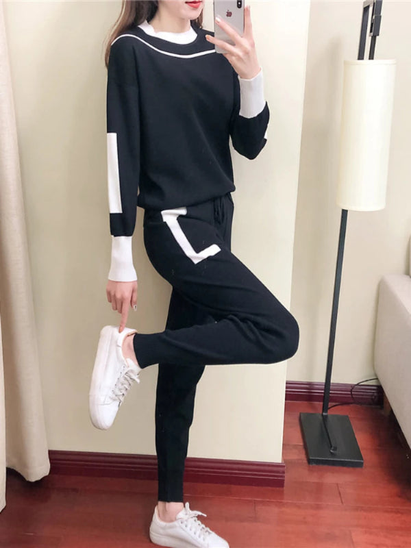 Person wearing a black and white outfit with white sneakers in a room.