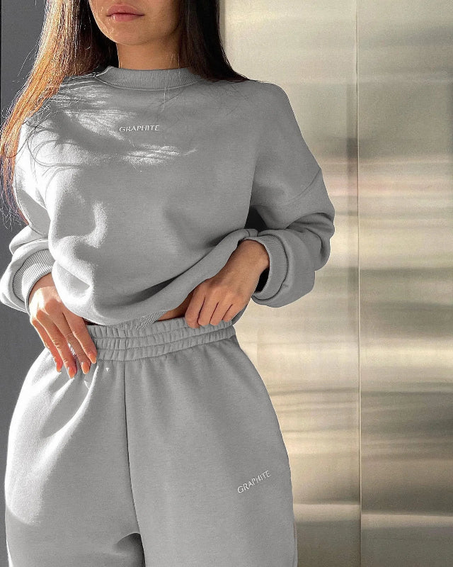 Person wearing a gray sweatshirt and pants with 'Grayrite' branding against a neutral background