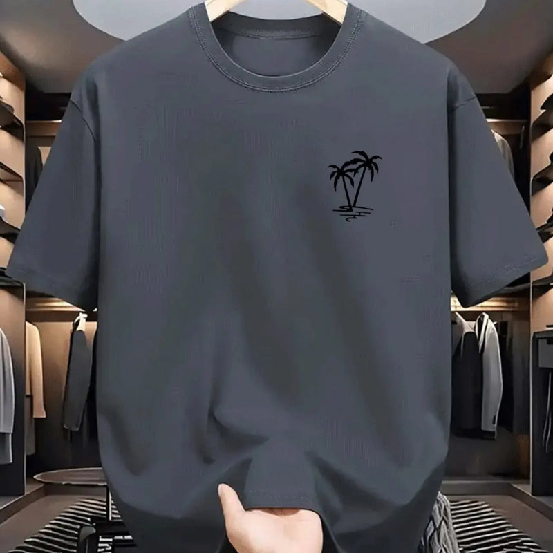 Gray t-shirt with a palm tree design held in a clothing store.