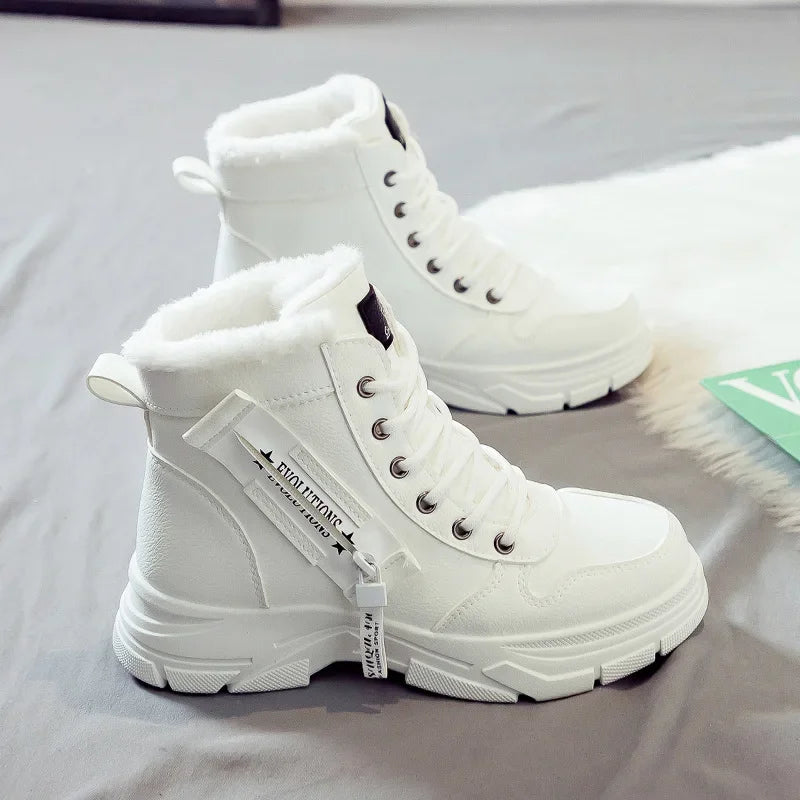 White winter boots with fur lining on a light gray background