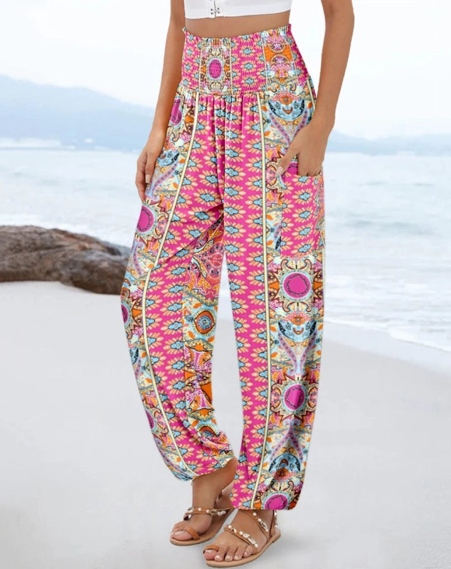 Colorful patterned pants worn by a person on a beach.