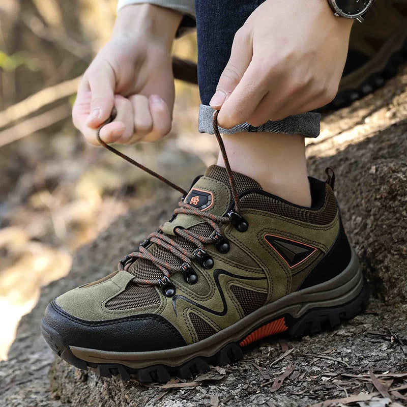 Person tying shoelaces on a hiking boot outdoors