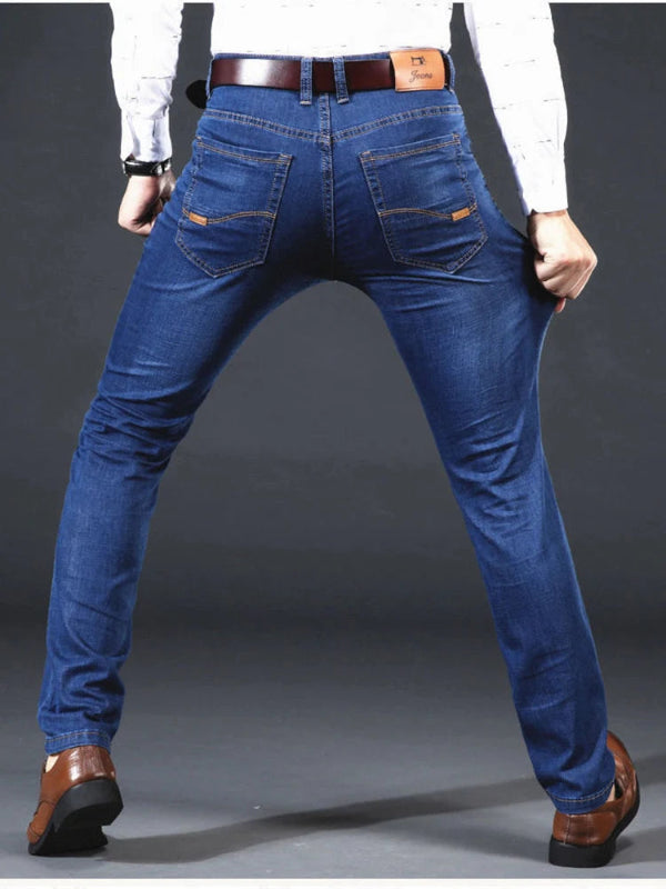 Person wearing blue jeans with a plain background