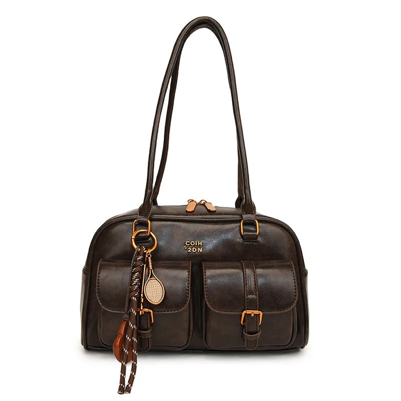 Brown leather handbag with gold accents on a white background