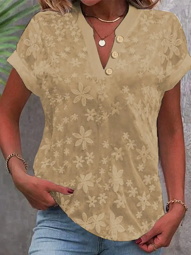 Beige floral blouse worn by a person with a neutral background