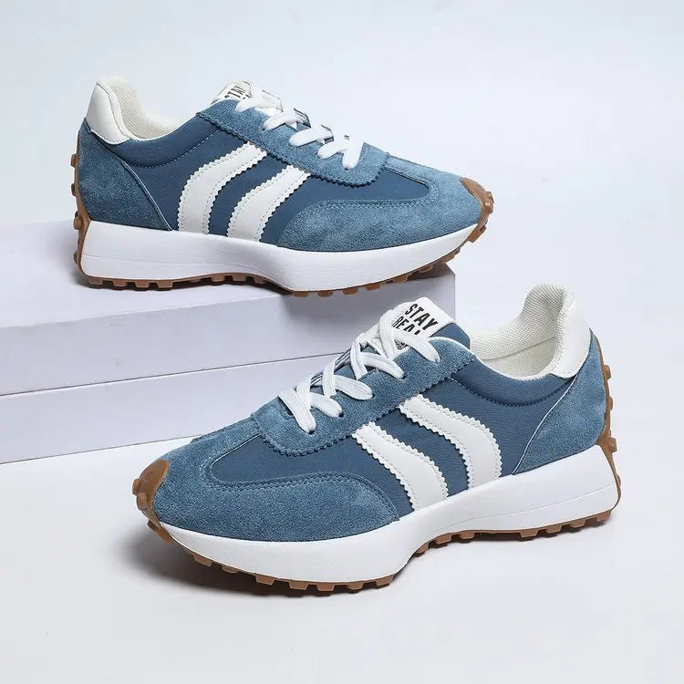 Blue sneakers with white stripes on a light gray background