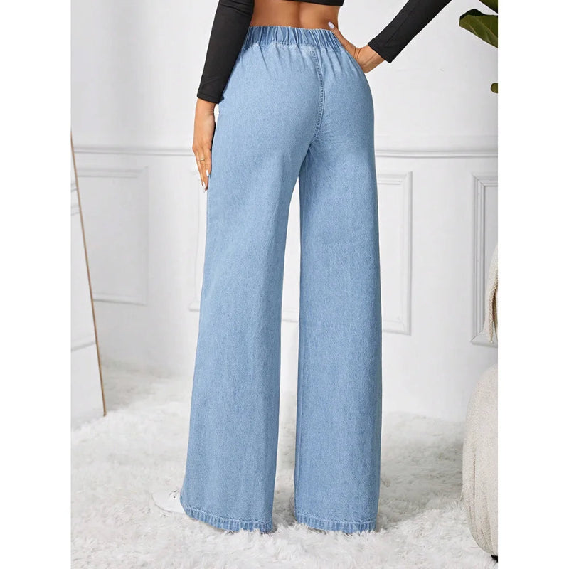 Light blue denim wide-leg pants worn by a person in a minimalistic setting.
