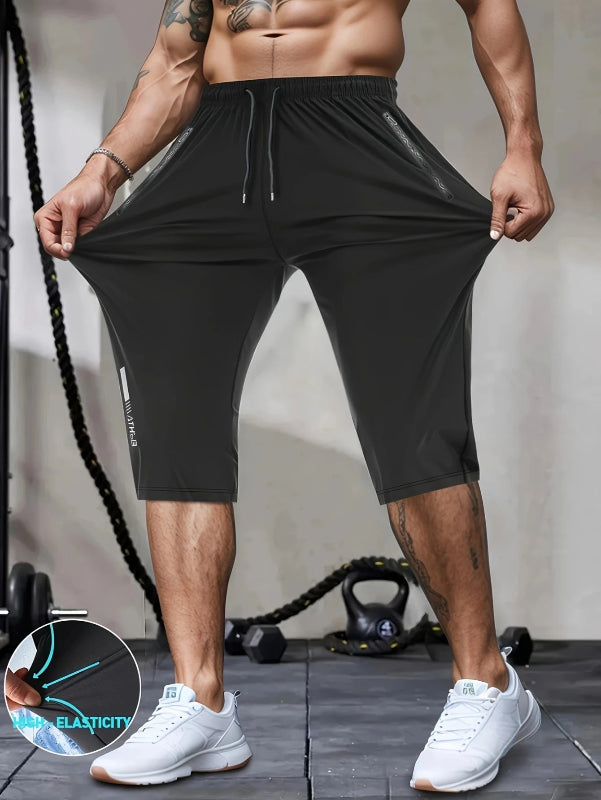 Person wearing black athletic shorts with a close-up of elasticity text in the corner.