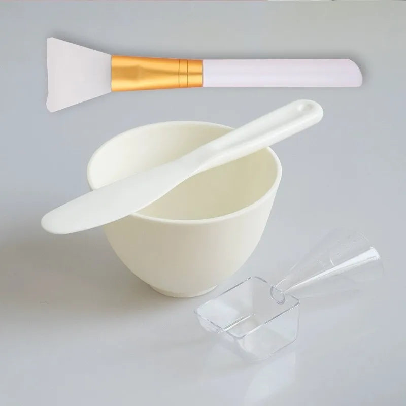 White mixing bowl with spatula and small container on a light gray background