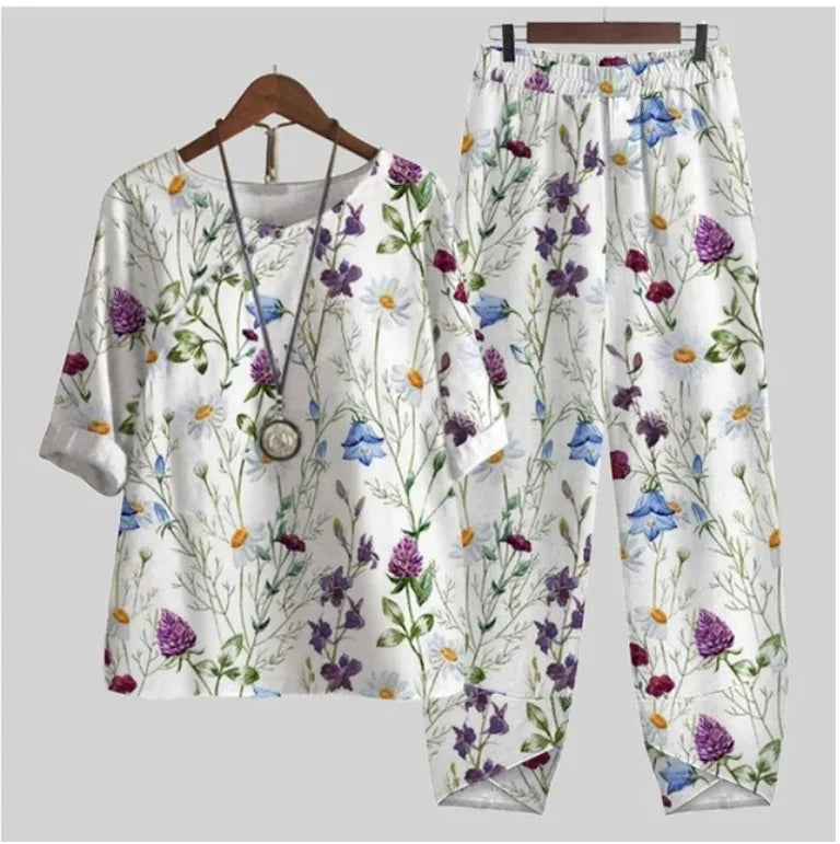 Floral-patterned shirt and pants set on a hanger against a light gray background