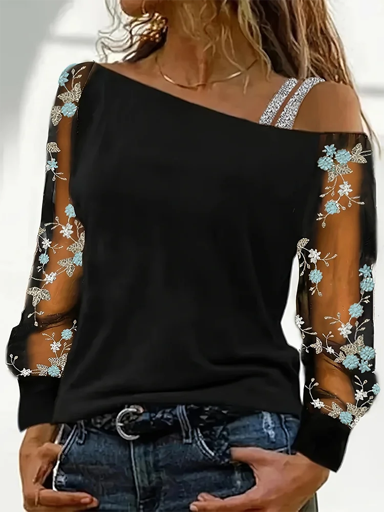 Black off-shoulder top with floral embroidery on sleeves and neckline.