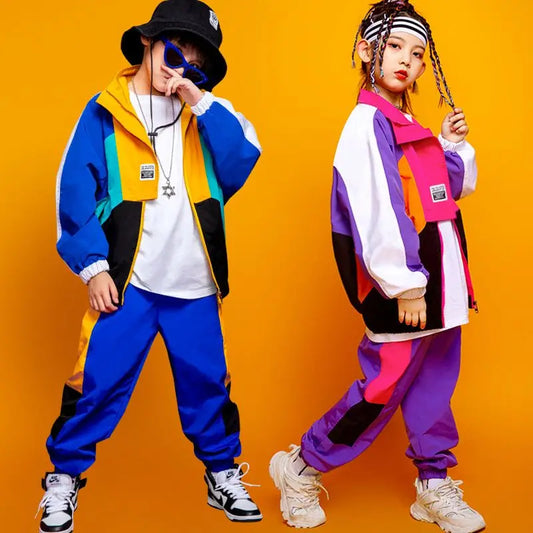 Two individuals wearing colorful outfits against an orange background