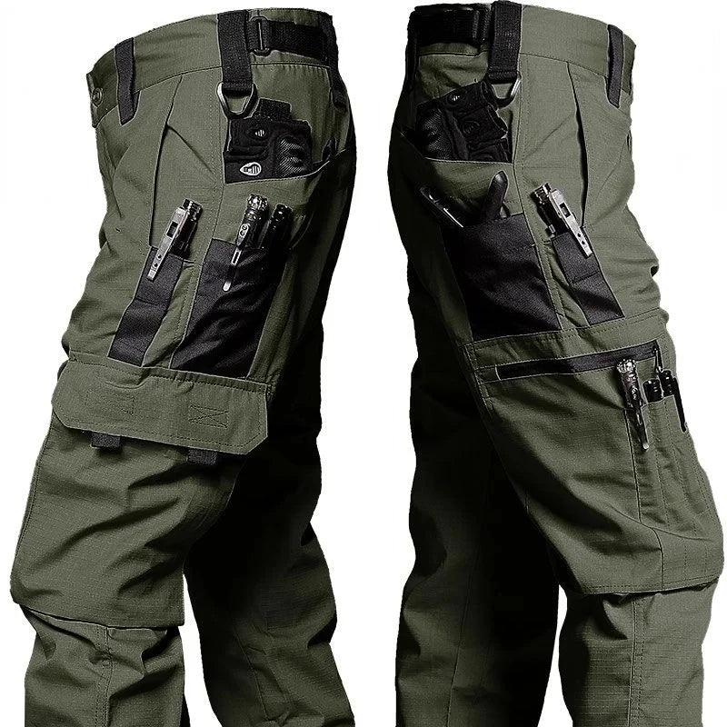 Pair of green tactical pants with multiple pockets and attachments on a white background
