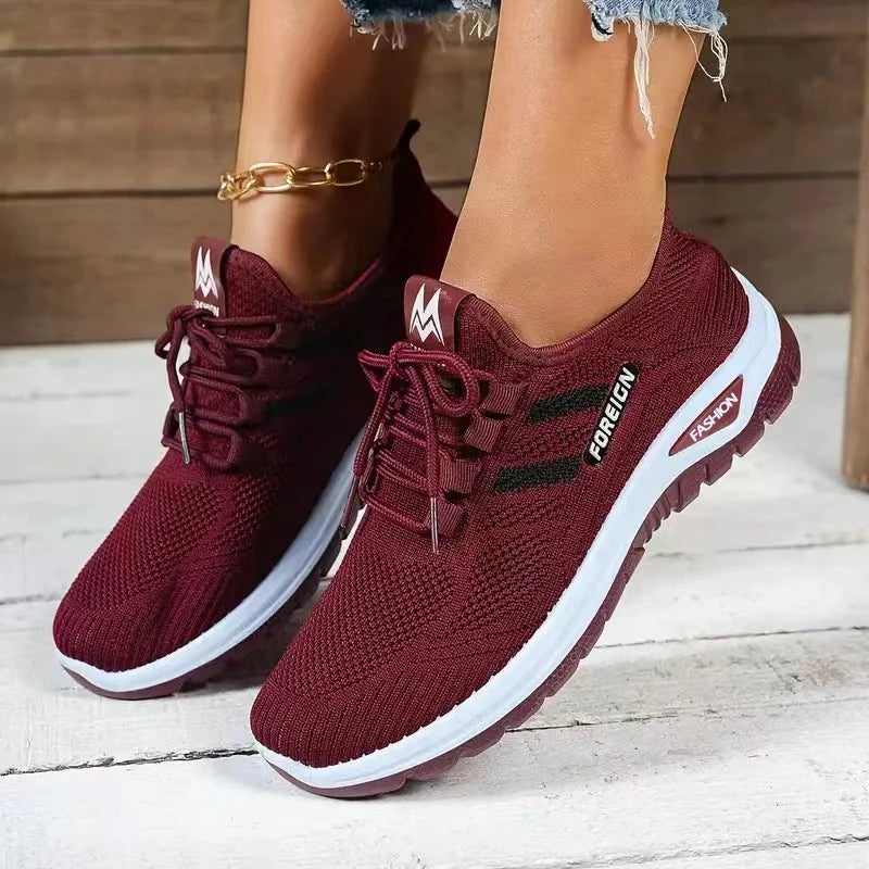 Maroon sneakers with white soles on a wooden floor