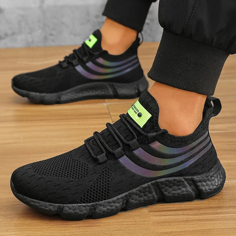 Black athletic shoes with colorful stripes worn by a person on a wooden floor.
