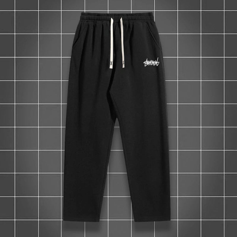 Black pants with a white logo on a gray grid background