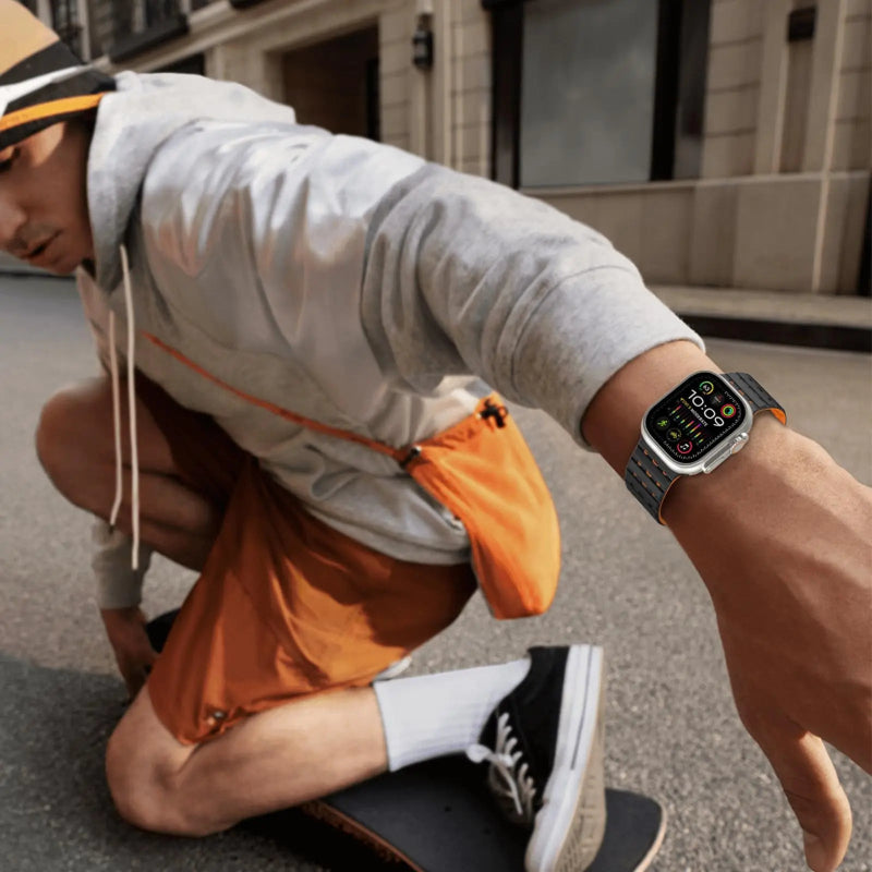 Person skateboarding wearing a smartwatch, crouched down on a street.
