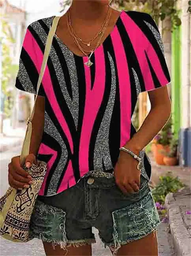 Person wearing a black and pink zebra print top with denim shorts outdoors.