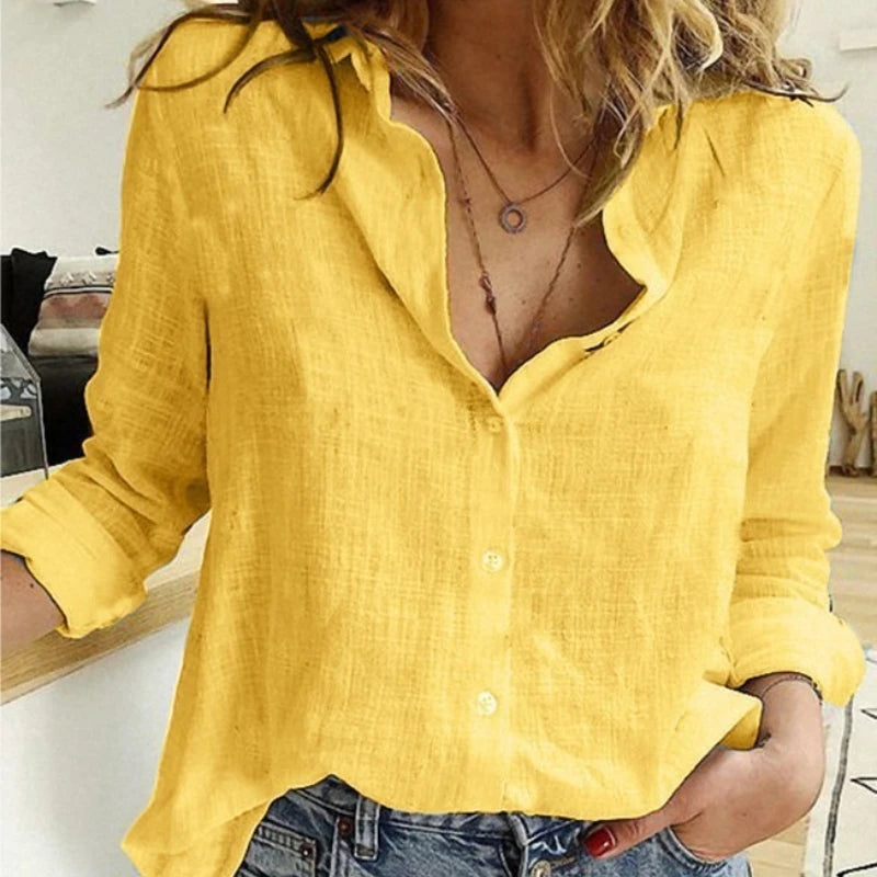 Person wearing a yellow button-up shirt with rolled-up sleeves in an indoor setting.