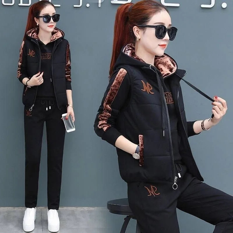 Woman wearing a black and brown tracksuit with sunglasses against a gray background