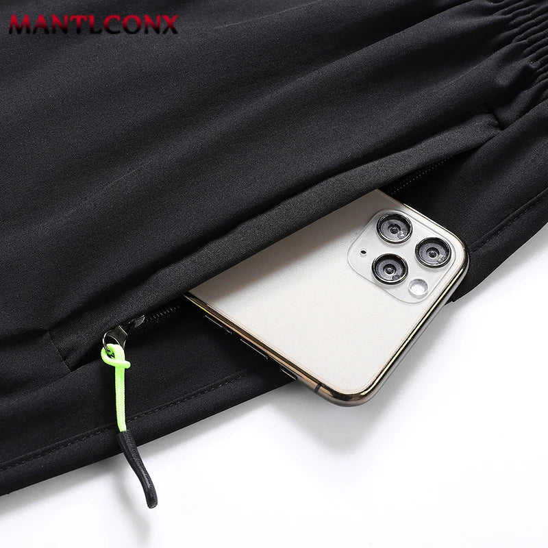 Phone in a pocket of a black jacket with 'MANTLCONX' branding.
