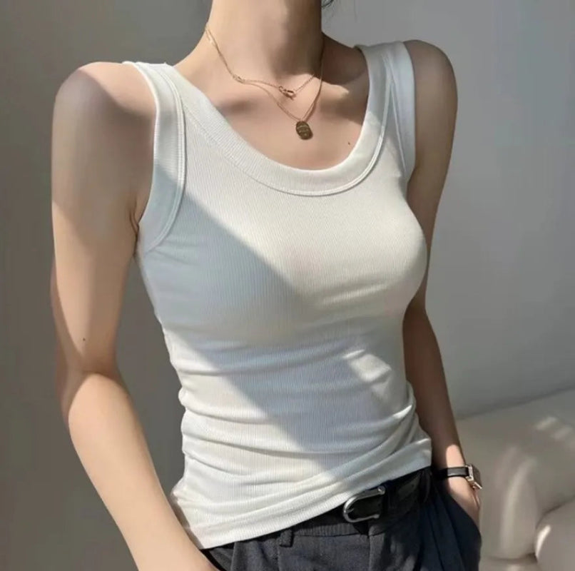 Mannequin wearing a white tank top and dark pants with a neutral background