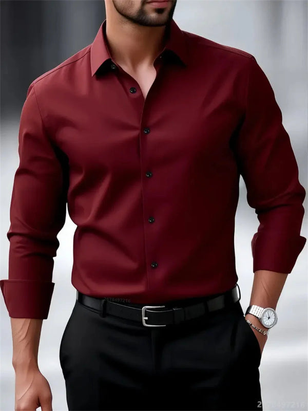 Man wearing a burgundy dress shirt with black buttons and black pants on a gray background