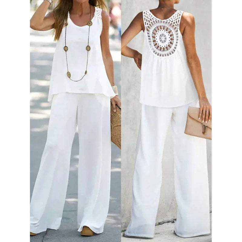 Two women wearing white outfits with crochet detailing on a blurred street background