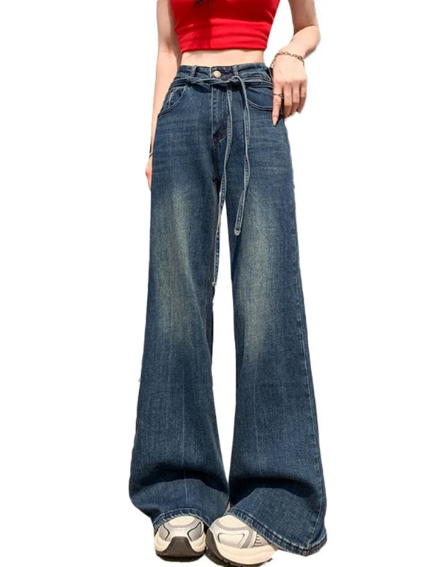 Person wearing blue wide-leg jeans on a white background