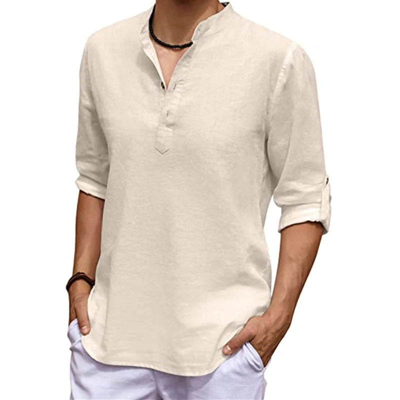 Man wearing a beige long-sleeve shirt and white pants on a white background