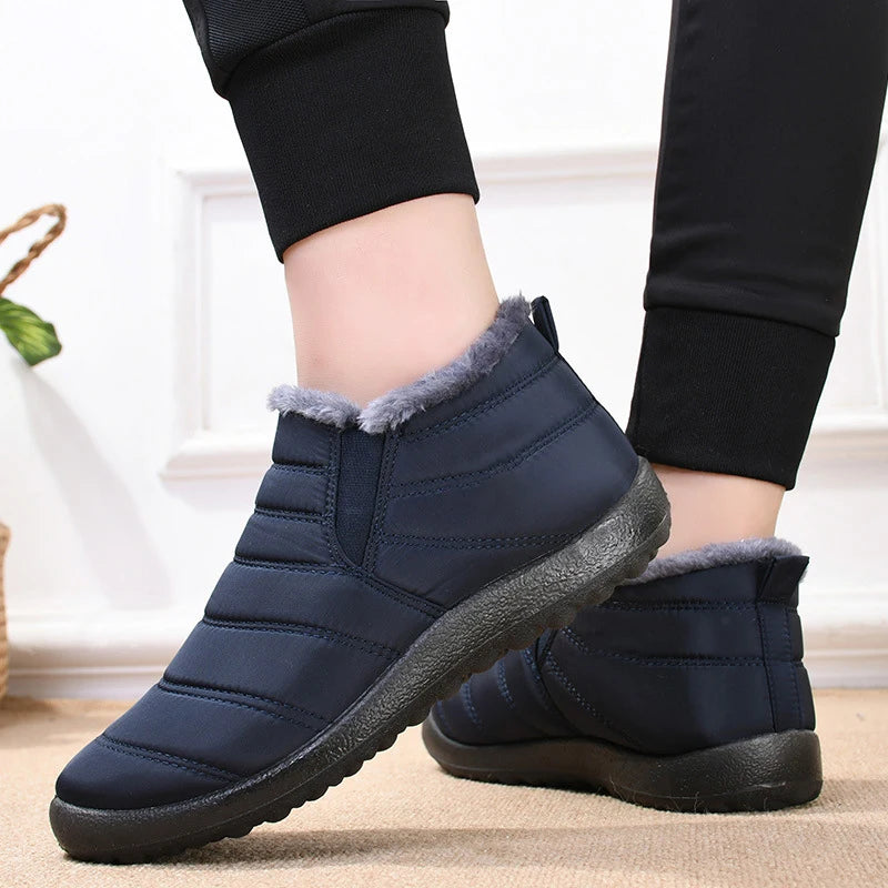 Navy blue winter boots with fur lining worn indoors on a light background