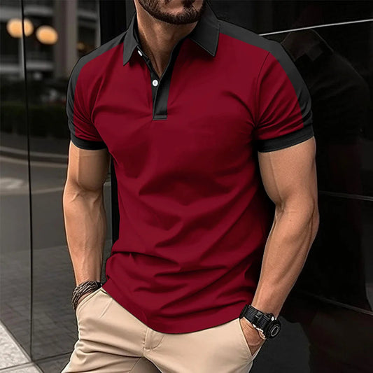 Man wearing a red and black polo shirt with beige pants, standing against a blurred background.