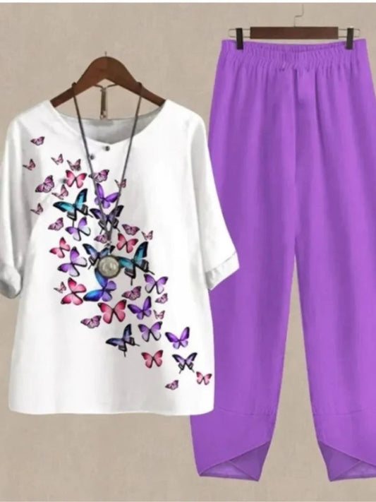 White t-shirt with butterfly design and purple pants on a beige background