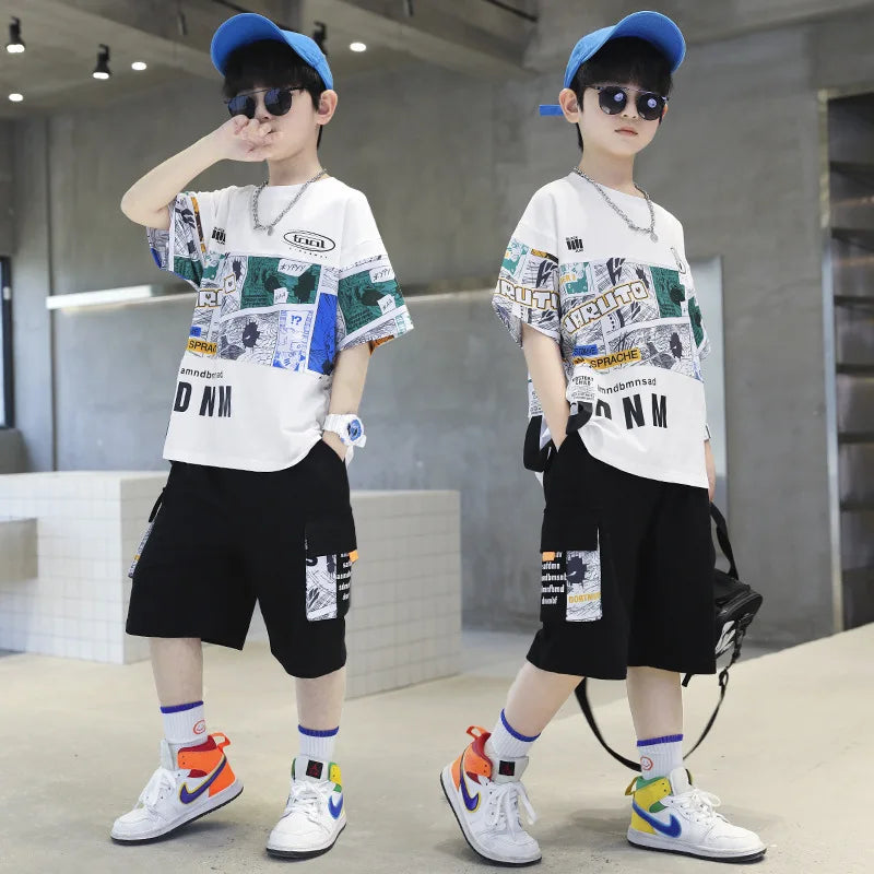 Two children wearing matching outfits with graphic t-shirts and shorts in a modern indoor setting.