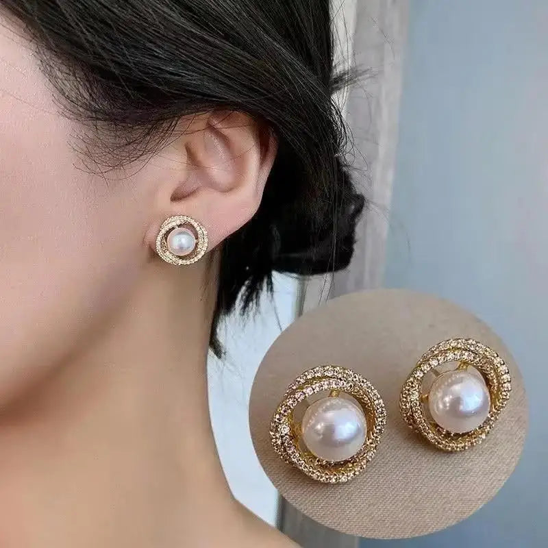 Pearl earrings with gold accents worn by a person, displayed on a neutral background.