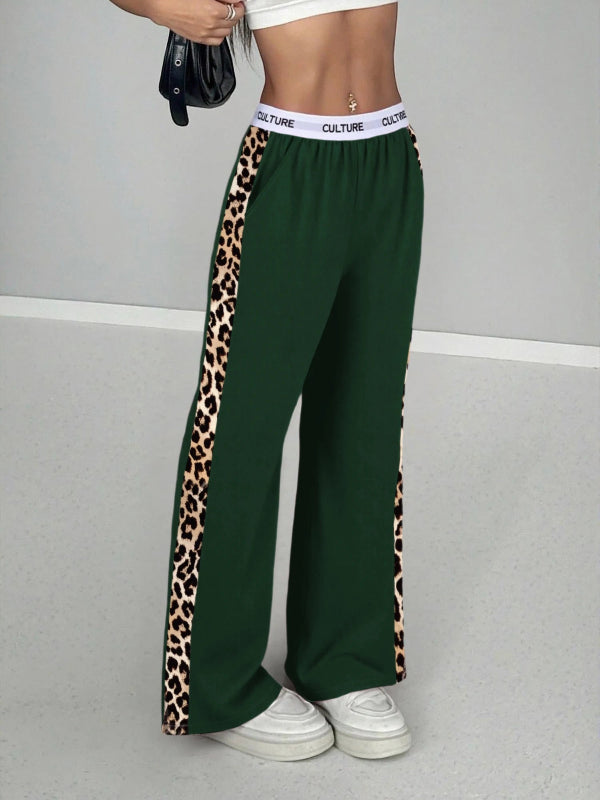 Green pants with leopard print side panels worn by a person on a gray background