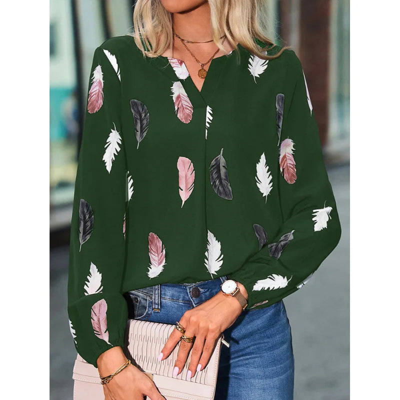Woman wearing a green blouse with feather pattern in an urban setting