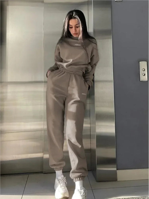 Person wearing a gray tracksuit standing in an elevator.