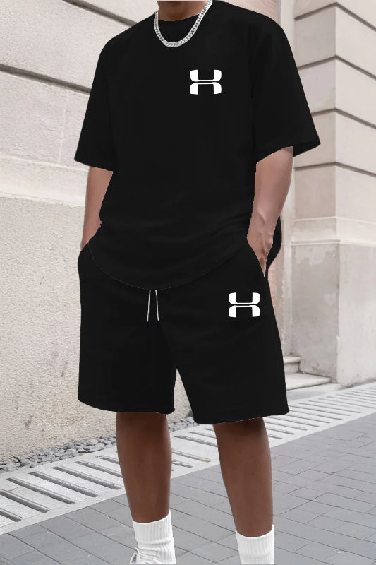 Person wearing a black Under Armour outfit with logo on a stone building background