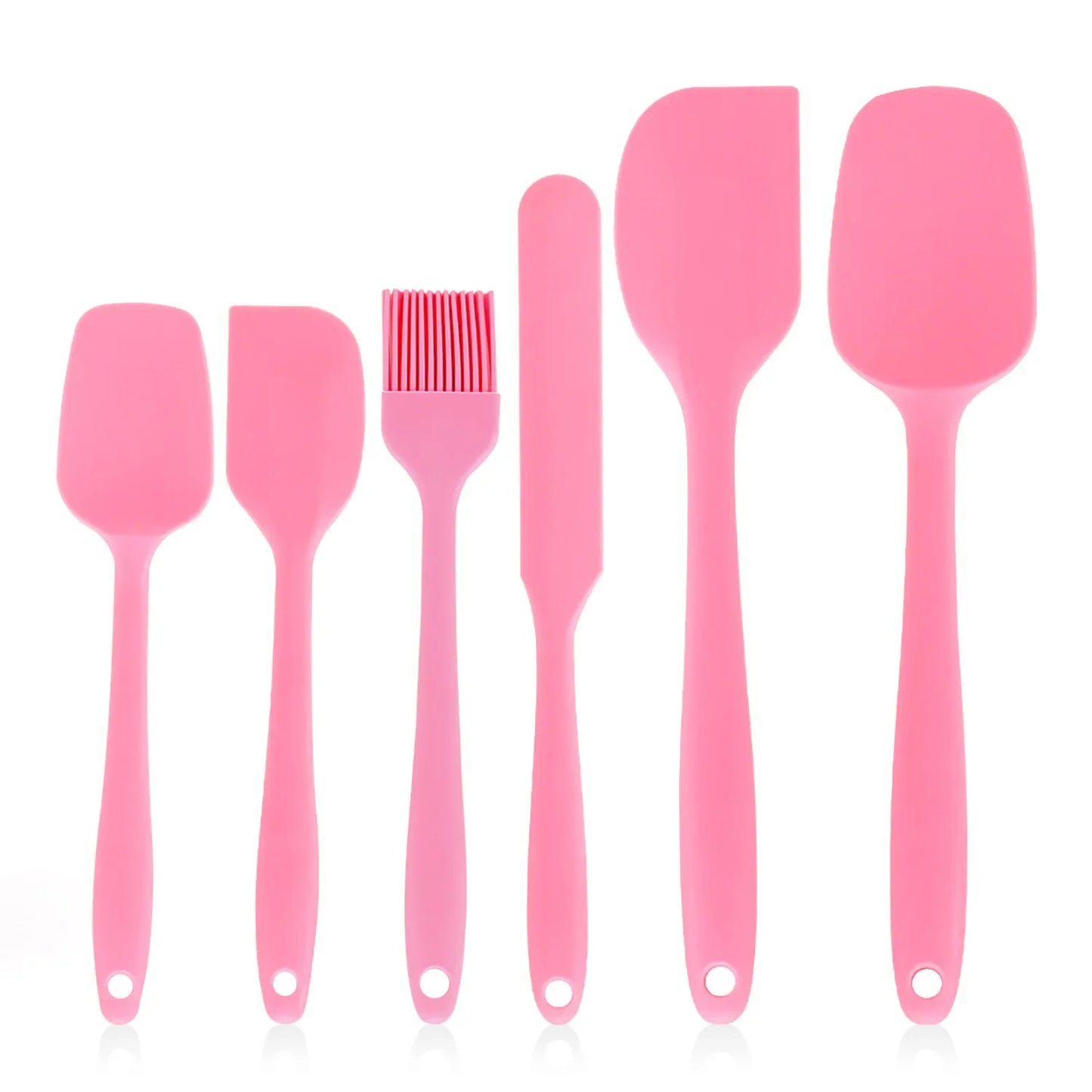 Set of pink silicone kitchen utensils on a white background