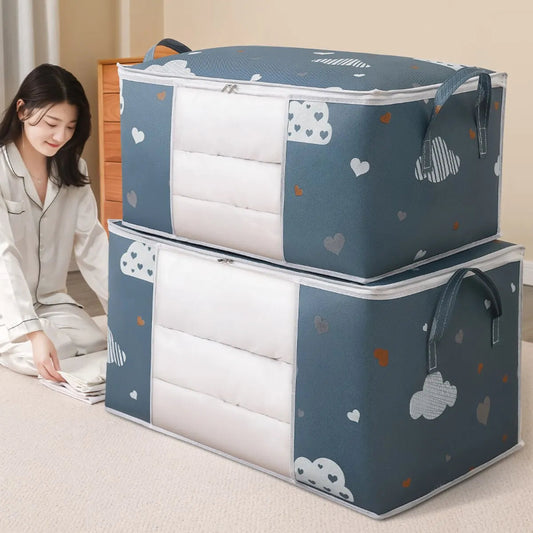 Woman sitting on the floor with two blue storage boxes featuring cloud patterns.