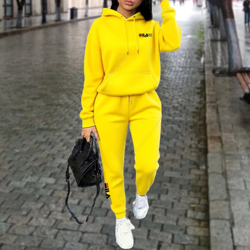 Person wearing a bright yellow hoodie and pants set on a city street.