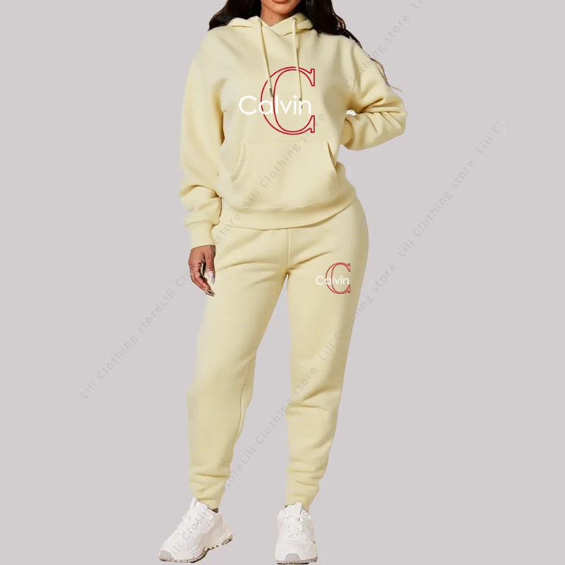 Person wearing a light yellow Calvin  tracksuit on a gray background