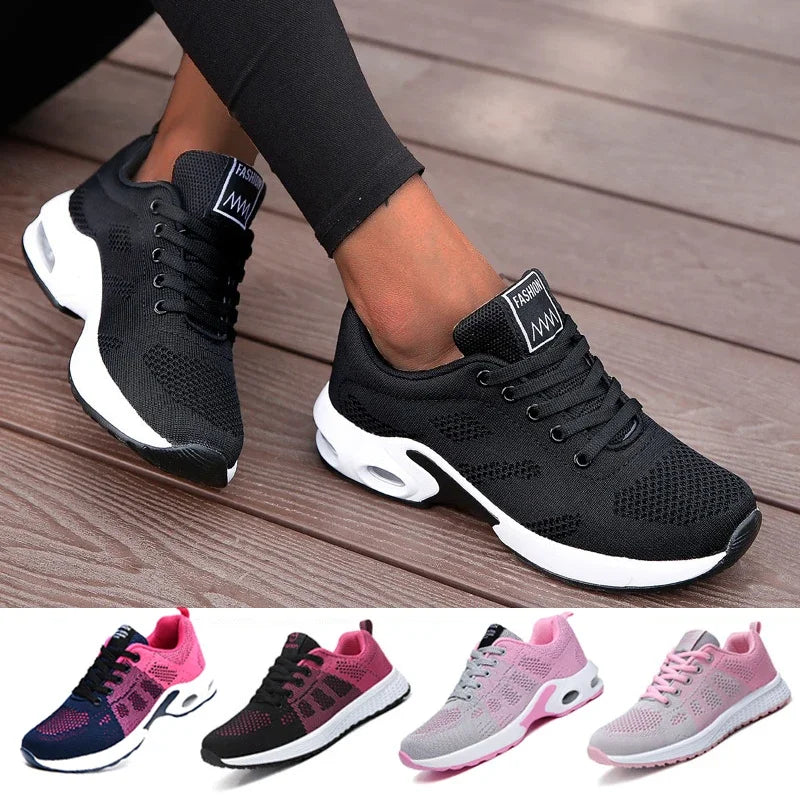 Black athletic shoes with white soles worn by a person on a wooden floor, with additional color options shown below.