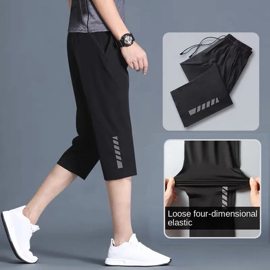 Person wearing black athletic shorts with a gray background, showing product details.