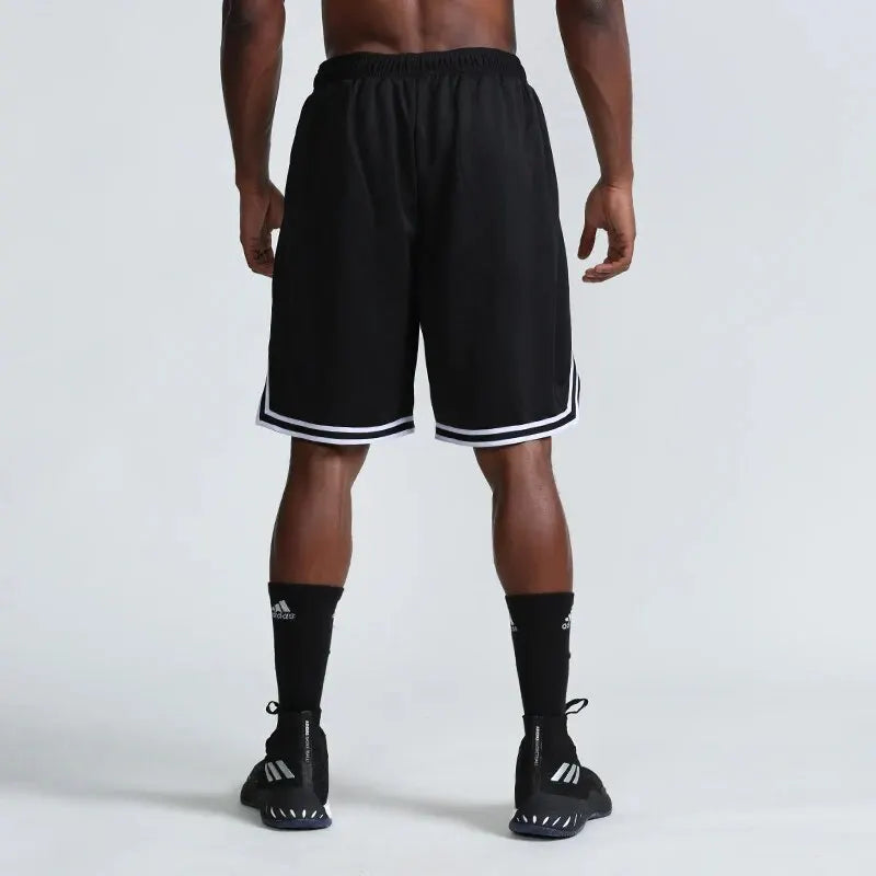 Person wearing black athletic shorts with white stripes on a light gray background